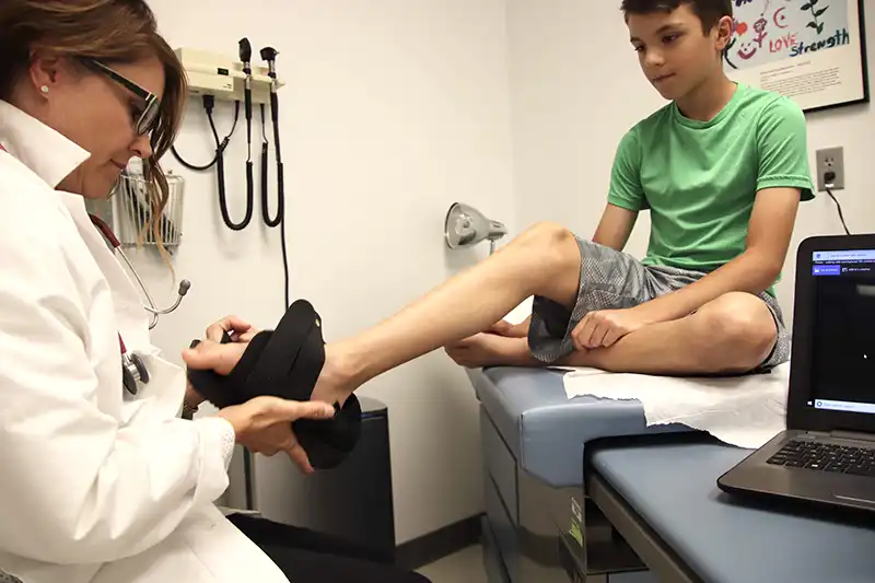 child getting ankle boot at urgent care for ankle injury
