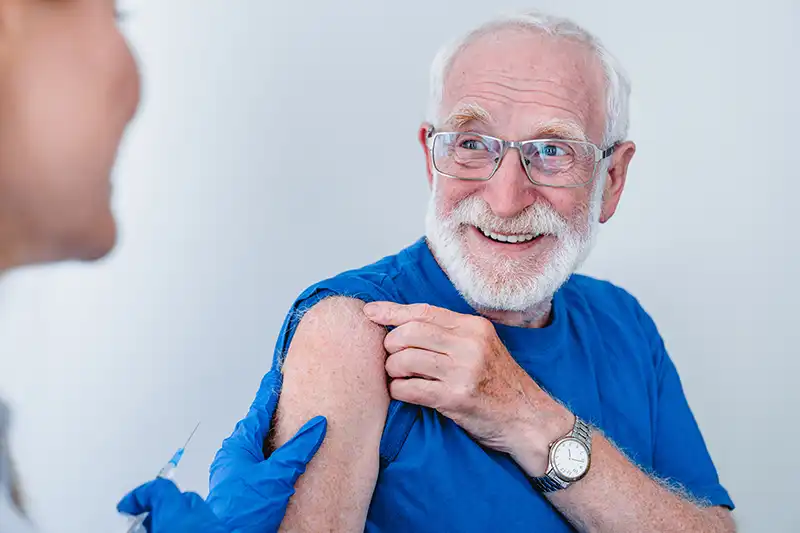 smiling elderly patient about to get vaccine