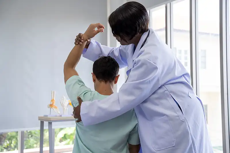 female chiropractor adjusting a patients shoulder